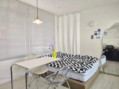 a hospital room with a bed and a table and chairs at Ilgwang 2Floor House in Busan