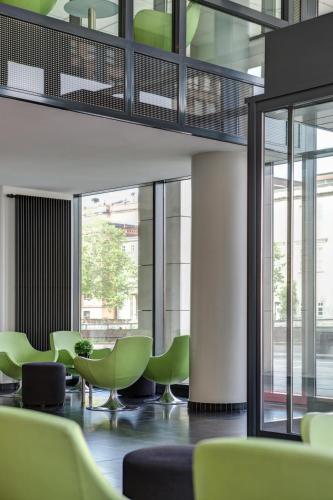a waiting room with green chairs and windows at IntercityHotel Hamburg Hauptbahnhof in Hamburg