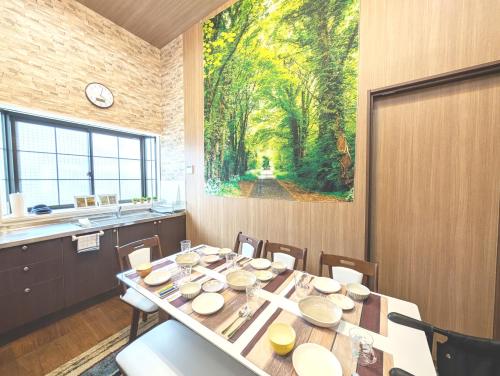 a dining room with a table and a painting on the wall at Nagoya Station is 17 minutes by car parking for 2 cars! Up to 11 people pets welcome! in Kiyosu