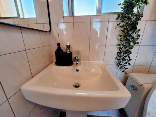 a white sink in a bathroom with a bottle of alcohol at Ilgwang 2Floor House in Busan