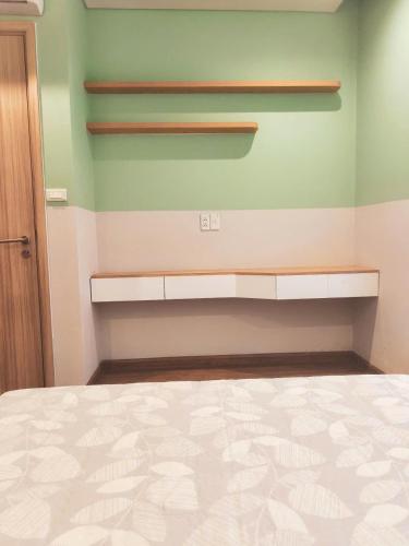 a bedroom with a bed and a green wall at Homestay Hạ Long NewLife in Kon Rung (1)