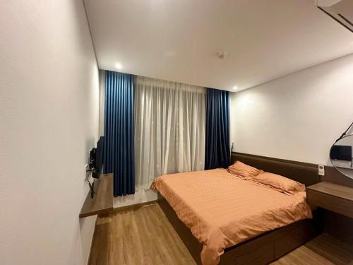 a small bedroom with a bed and a television at Homestay Hạ Long NewLife in Kon Rung (1)