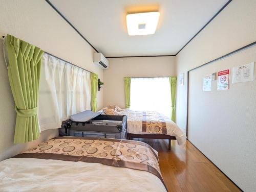 a room with two beds and a window at Nagoya Station is 17 minutes by car parking for 2 cars! Up to 11 people pets welcome! in Kiyosu