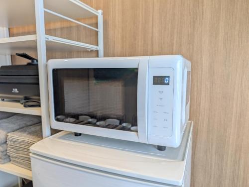 a microwave oven sitting on top of a refrigerator at Nagoya Station is 17 minutes by car parking for 2 cars! Up to 11 people pets welcome! in Kiyosu