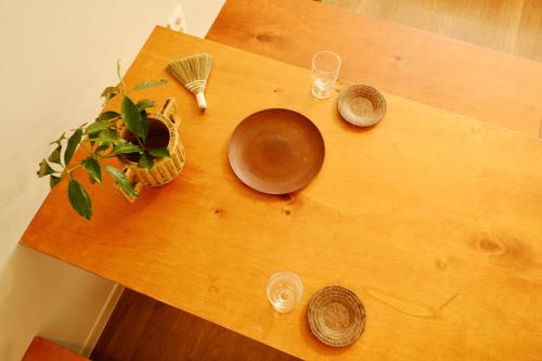 a wooden table with glasses and a plant on it at Pyoseon Mansion in Seogwipo