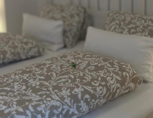 a brown and white pillow with a green object on it at Haus Berta, Montafon in Partenen