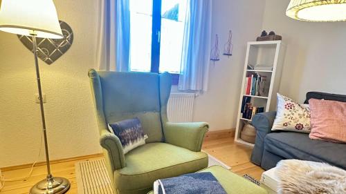 a living room with a blue chair and a couch at Haus Berta, Montafon in Partenen