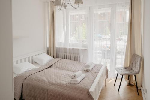una camera da letto con un letto, una sedia e una finestra di Wita Stwosza Rynek Apartament Wrocław a Breslavia