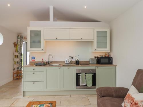 a kitchen with white cabinets and a sink at The Pennymoor in Tiverton