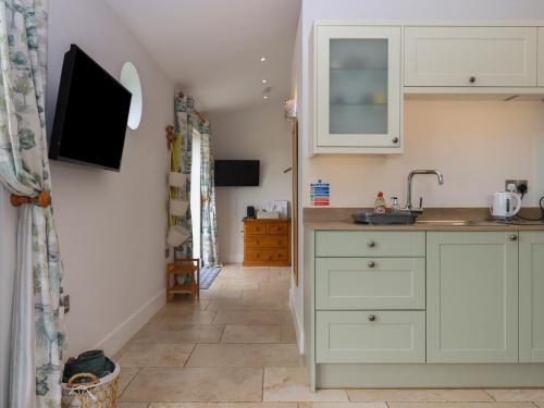 a kitchen with white cabinets and a sink at The Pennymoor in Tiverton