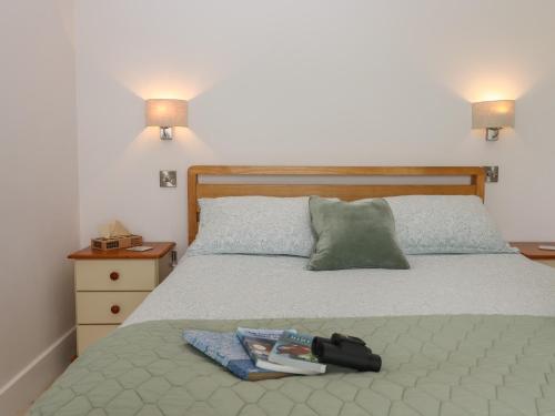 a bedroom with a bed with a book on it at The Pennymoor in Tiverton