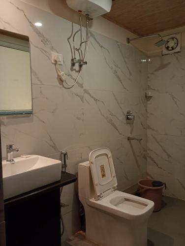 ガントクにあるHotel Tibet Galleryの白いトイレと洗面台のあるバスルーム