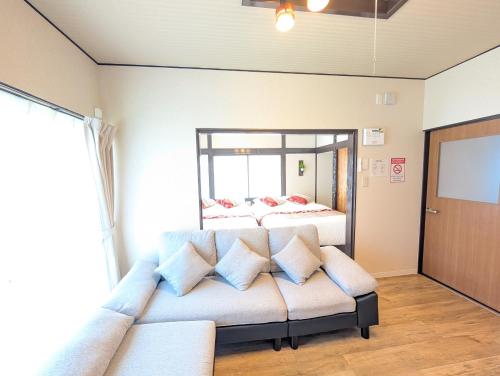 a living room with two beds and a couch at Nagoya Station is 17 minutes by car parking for 2 cars! Up to 11 people pets welcome! in Kiyosu