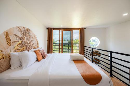 MungguにあるCove Kisah Residenceの大きな白いベッドと窓のある寝室