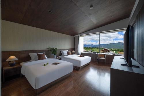 ein Schlafzimmer mit zwei Betten und einem großen Fenster in der Unterkunft Sunny Aerie丨 Golden Peak Resort in Baisha