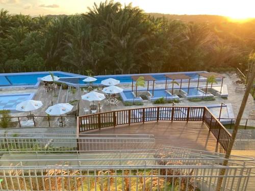 a pool with a bunch of umbrellas and a deck at Apartamento Inteiro Mobiliado in Parnamirim