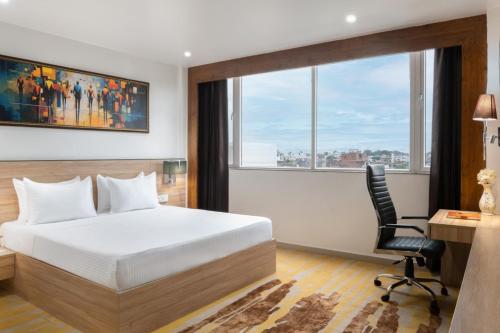 a bedroom with a bed and a desk and a chair at Clarks Inn Basti in Basti