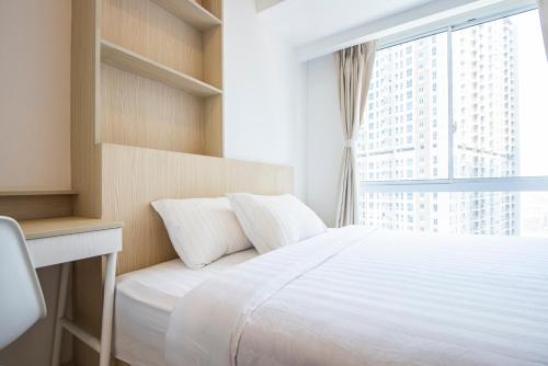a bedroom with a white bed and a window at Tokyo Riverside Apartment @ PIK 2 in Tangerang