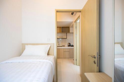 a small bedroom with a bed and a small kitchen at Tokyo Riverside Apartment @ PIK 2 in Tangerang