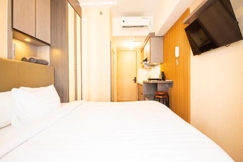 a hotel room with a bed and a television at Tokyo Riverside Apartment @ PIK 2 in Tangerang