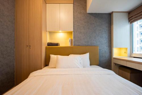 a bedroom with a large bed with white pillows at Tokyo Riverside Apartment @ PIK 2 in Tangerang