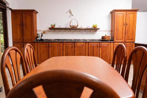 a kitchen with a wooden table and wooden cabinets at Luna House Nawala in Sri Jayewardenepura Kotte