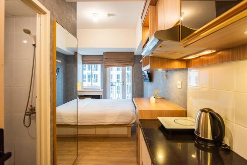 a small bathroom with a bed and a sink at Tokyo Riverside Apartment @ PIK 2 in Tangerang