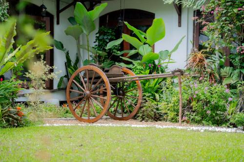 a wooden cart sitting in the grass in front of a house at Luna House Nawala in Sri Jayewardenepura Kotte