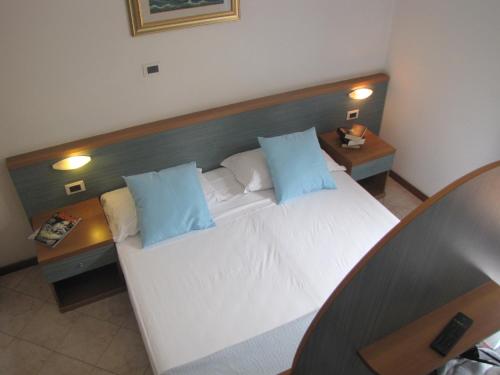 a bedroom with a large white bed with blue pillows at Residence Villa Margherita in Brenzone sul Garda