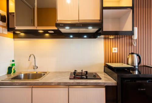 a kitchen with a sink and a stove at Tokyo Riverside Apartment @ PIK 2 in Tangerang