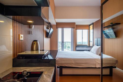 a bedroom with a bed and a desk in a room at Tokyo Riverside Apartment @ PIK 2 in Tangerang