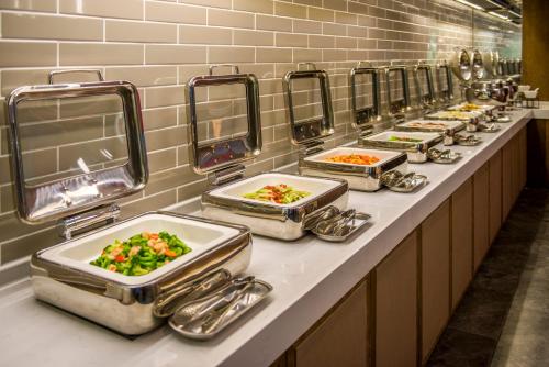 a row of trays of food on a buffet line at Ease Hotel · Yi (Xi’an Bell and Drum Tower Xiaozhai Datang Everbright City) in Xi'an