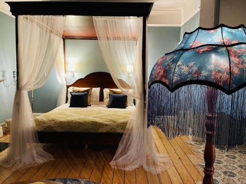 una camera con letto a baldacchino e tende bianche di Tranquil Victorian Villa with Hot Tub & Sauna a Colwyn Bay