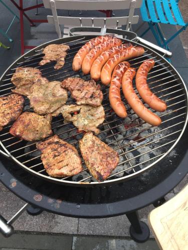 a grill with sausage and hamburgers on it at Haus Berta, Montafon in Partenen