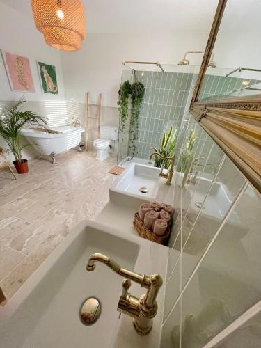 a bathroom with a tub and a sink and a bath tub at Tranquil Victorian Villa with Hot Tub & Sauna in Colwyn Bay
