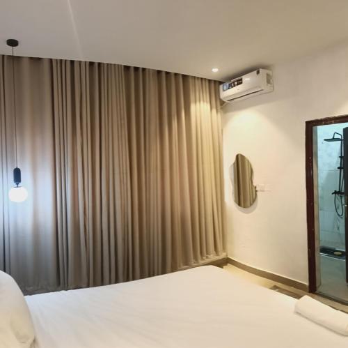 a hotel room with a bed and a window at Delight Apartment in Ikeja