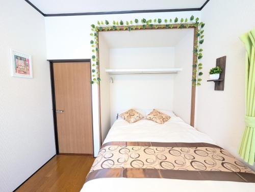 a bedroom with a bed with areath on the wall at Nagoya Station is 17 minutes by car parking for 2 cars! Up to 11 people pets welcome! in Kiyosu