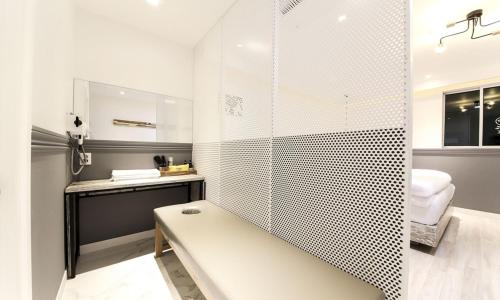 a bathroom with a shower with a bench and a sink at Hotel Yeogieutte Dongdaegu in Daegu
