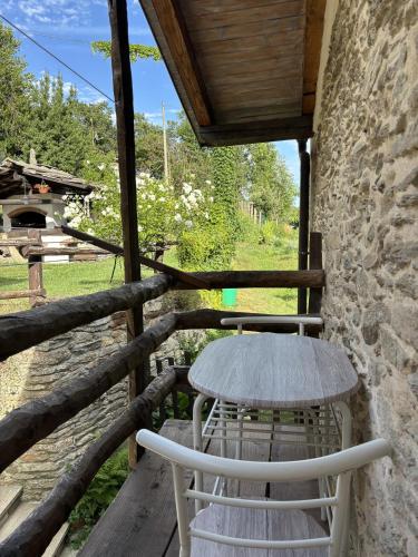 a table and chairs on the porch of a cabin at Casetta immersa nella natura in Ostana