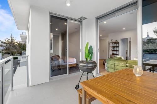 a kitchen and living room with a table and glass doors at Modern 2BR near The Gabba & BBQ in Brisbane
