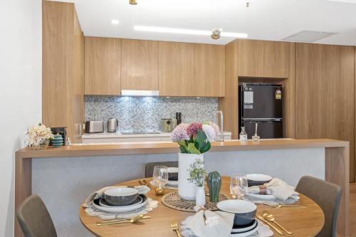 a kitchen with a table with plates and flowers on it at Modern 2BR near The Gabba & BBQ in Brisbane