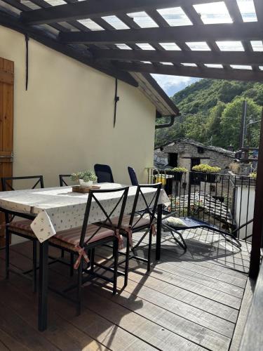 a table and chairs on a patio with a view at Casetta immersa nella natura in Ostana