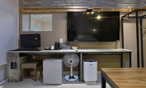 a desk with a computer and a monitor and a fan at Hotel Yeogieutte Dongdaegu in Daegu