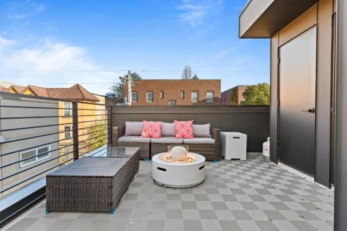 a patio with a couch and a table on a balcony at NEW Townhome in the Heart of Seattle in Seattle