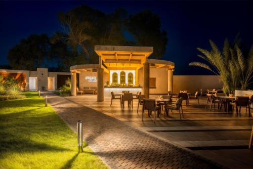 a patio with tables and chairs at night at Merit Royal Gardens Hotel & Casino in İskele