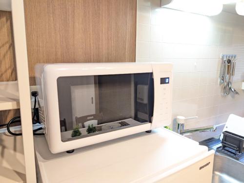 a microwave oven sitting on a shelf in a kitchen at 17minutes by car to Nagoya-Sta 1parking in Chiharachō