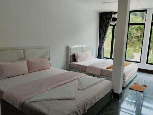 two beds sitting in a room with windows at Waterfall Guesthouse1 in Phumĭ Kaôh Rŏng