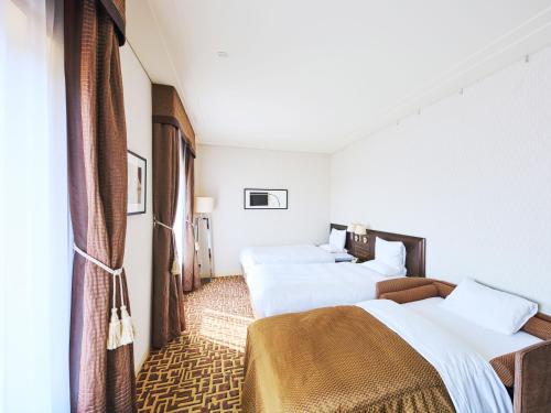 a hotel room with two beds and a window at Okura Chiba Hotel in Chiba