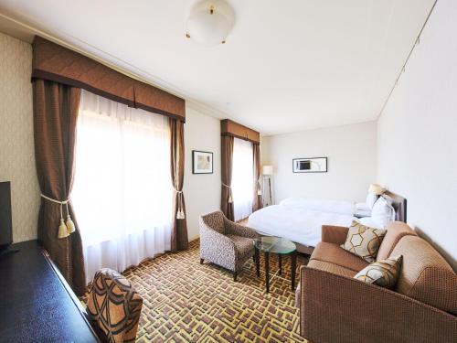 a hotel room with a bed and a couch at Okura Chiba Hotel in Chiba