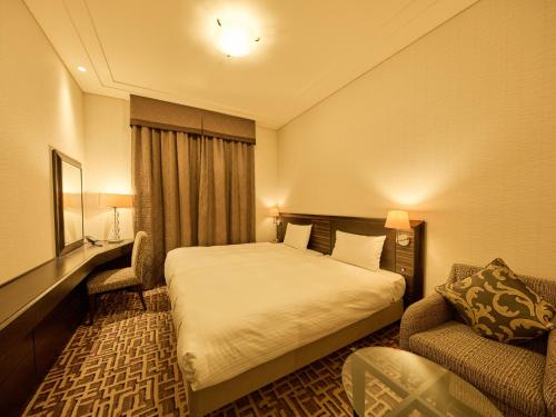 a hotel room with a bed and a couch at Okura Chiba Hotel in Chiba